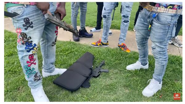 A video posted online earlier this year showed a group of men brandishing guns and flashing gang signs in front of the Pinebrooke Apartments near Riverdale. (Miko Worldwide / YouTube)