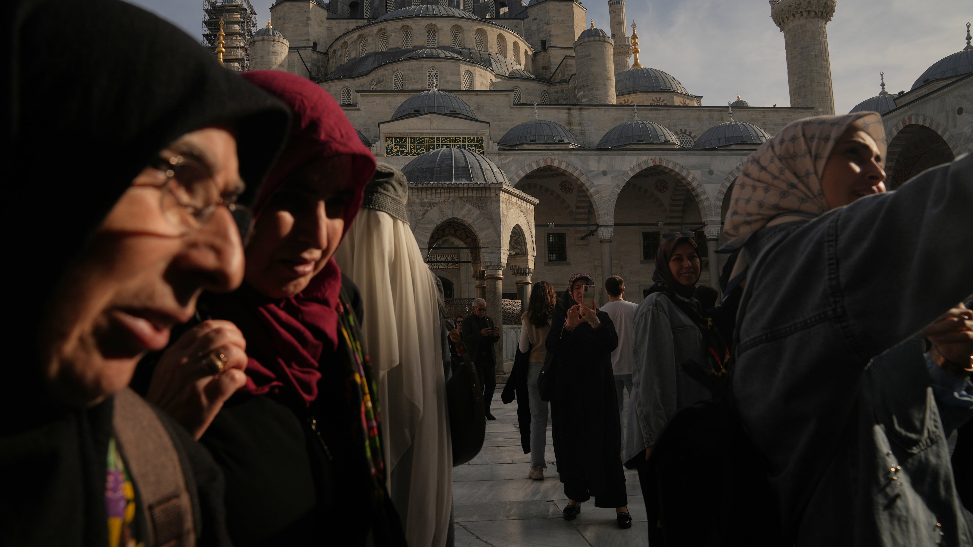 Locals and tourists visit the Ottoman-era Sultan Ahmed or Blue Mosque, in Istanbul, Turkey, Friday, Nov. 21, 2025, ahead of the visit of Pope Leo XIV to Turkey. (AP Photo/Francisco Seco)
