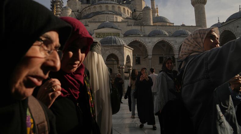 Locals and tourists visit the Ottoman-era Sultan Ahmed or Blue Mosque, in Istanbul, Turkey, Friday, Nov. 21, 2025, ahead of the visit of Pope Leo XIV to Turkey. (AP Photo/Francisco Seco)