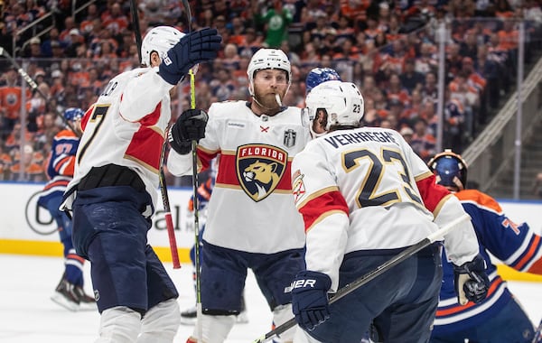 Florida Panthers' Dmitry Kulikov (7), Sam Bennett (9) and Carter Verhaeghe (23) celebrate a goal against the Edmonton Oilers during the first period in Game 1 of the NHL Stanley Cup final in Edmonton, Wednesday, June 4, 2025. (Jason Franson/The Canadian Press via AP)