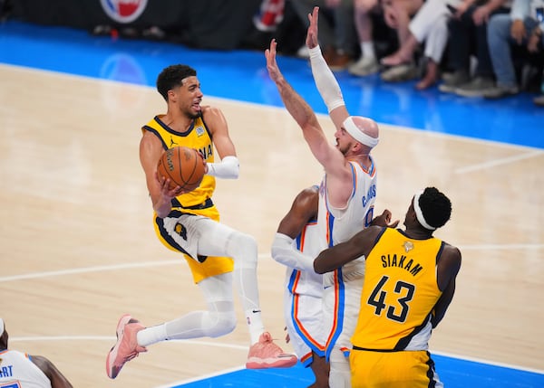 Indiana Pacers guard Tyrese Haliburton (0) shoots against Oklahoma City Thunder guard Alex Caruso (9) during the second half of Game 1 of the NBA Finals basketball series Thursday, June 5, 2025, in Oklahoma City. (AP Photo/Julio Cortez)