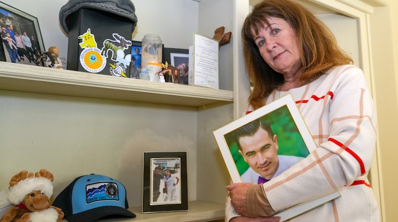 Kelley Nalewaja stands by a memorial for her son, Michael Nalewaja, seen in the photo, who died after unknowingly taking a lethal cocktail of fentanyl and carfentanil in November 2025, at her home in El Dorado Hills, Calif., Thursday, April 16, 2026. (AP Photo/Rich Pedroncelli)