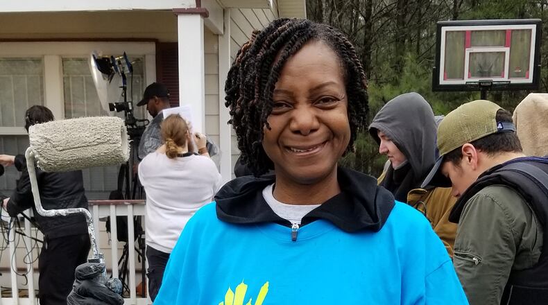 Catherine Chandler helps volunteers from Art Institute of Atlanta spruce up the exterior of her almost 20-year-old Habitat for Humanity home.