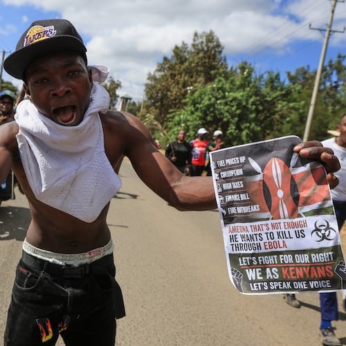 A protester holds up a sign during a demonstration against a proposed Ebola quarantine center to be established by the United States at Laikipia Air Base, in Nanyuki, Kenya, Monday, June 1, 2026. (AP Photo/Andrew Kasuku)