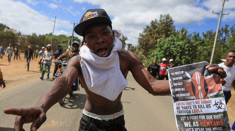 A protester holds up a sign during a demonstration against a proposed Ebola quarantine center to be established by the United States at Laikipia Air Base, in Nanyuki, Kenya, Monday, June 1, 2026. (AP Photo/Andrew Kasuku)