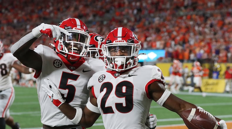Georgia defensive back Christopher Smith (right) strikes a pose alongside teammate Kelee Ringo after intercepting a pass against Clemson and returning it 74 yards for a touchdown in the second quarter of what ended as a 10-3 win over the No. 3-ranked Tigers in the Dukes Mayo Classic in Charlotte on Sept. 4, 2021. (Photo by Curtis Compton/ccompton@ajc.com)