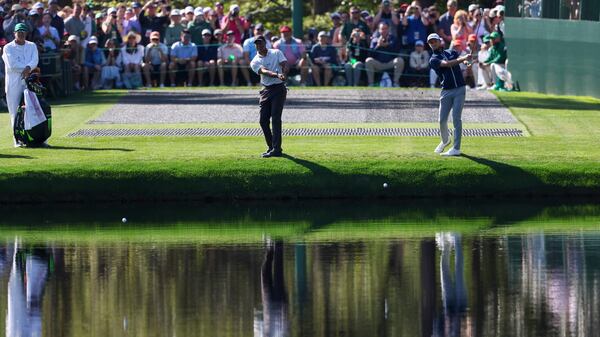 Tiger Woods, left, and Will Zalatoris attempt to skip a ball across on the pond on the 16th hole during the practice round of the 2024 Masters Tournament at Augusta National Golf Club, Monday, April 8, 2024, in Augusta, Ga. (Jason Getz / jason.getz@ajc.com)