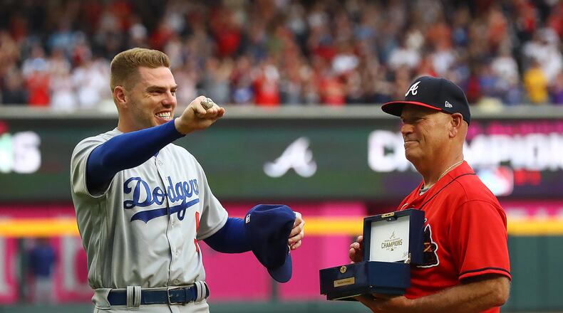 Atlanta: Braves manager Brian Snitker, right, presents former Atlanta Braves first baseman Freddie Freeman his World Series Championship ring, who shows it off to the fans during his ring presentation ceremony as he returns to Atlanta with the Los Angles Dodgers at Truist Park on Friday, June 24, 2022, in Atlanta. The series marks Freeman's first games in Atlanta since the longtime Braves star signed with the Dodgers as a free agent in March. (Curtis Compton/ccompton@ajc.com)