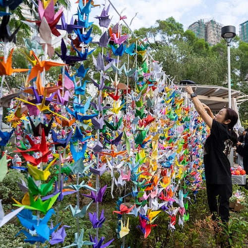 People hang paper cranes near the site of the fire at Wang Fuk Court, a residential estate in the Tai Po district of Hong Kong's New Territories on Wednesday, Dec 3, 2025. (AP Photo/Chan Long Hei)