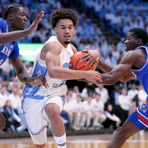 North Carolina guard Seth Trimble, center, drives between Kansas forward Flory Bidunga, left, and guard Melvin Council Jr. (14) during the first half of an NCAA college basketball game Friday, Nov. 7, 2025, in Chapel Hill, N.C. (AP Photo/Chris Seward)