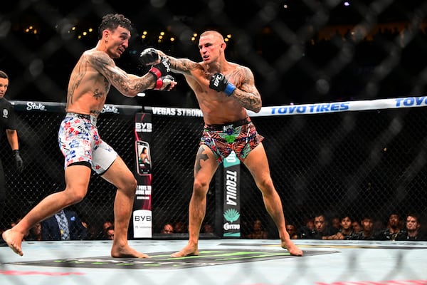 Dustin Poirier, right, hits Max Holloway in a lightweight title fight at UFC 318 in New Orleans, La., Saturday, July 19, 2025. (AP Photo/Ella Hall)