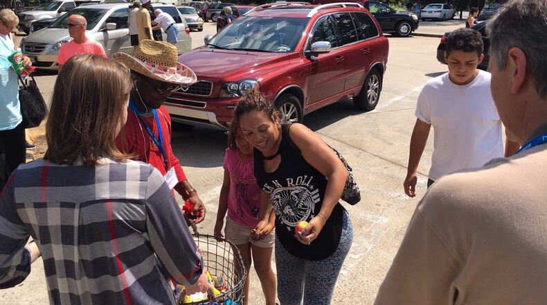 Luis Perez, in the white shirt, and his mother take snacks and drinks given out by a Macon church at a Bibb County rest stop Friday, Sept. 8, 2017. Perez, 15, said 10 of his family members drove in two cars from Homestead, Florida, to escape Hurricane Irma.