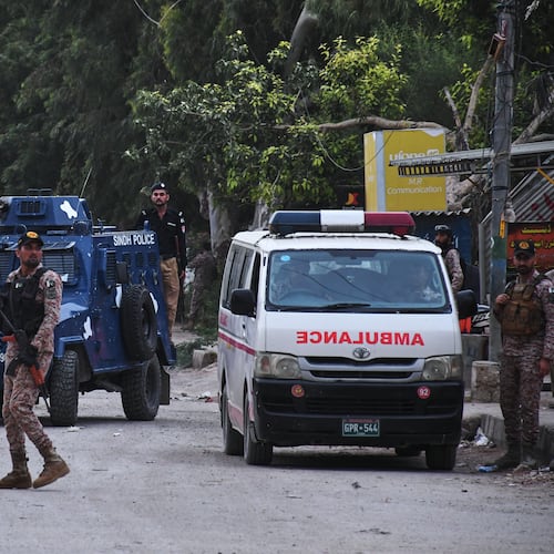 Paramilitary soldiers and police officers stand guard on a road cordoned off near the site of a militant attack at the provincial headquarters of the paramilitary Pakistan Rangers in Karachi, Pakistan, Sunday, June 28, 2026. (AP Photo/Ali Raza)