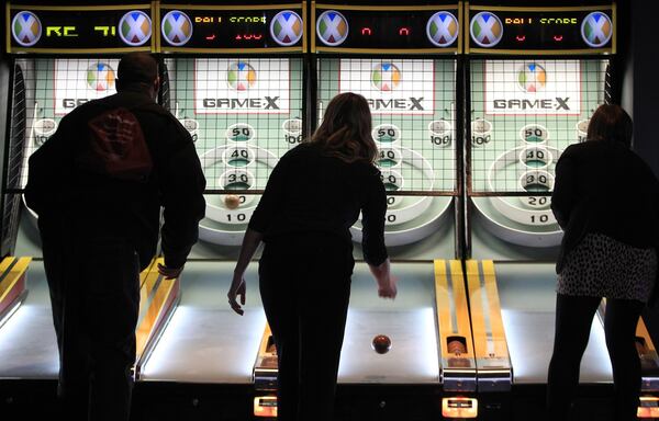 Players compete in a game of skee ball at Game-X. CURTIS COMPTON / CCOMPTON@AJC.COM