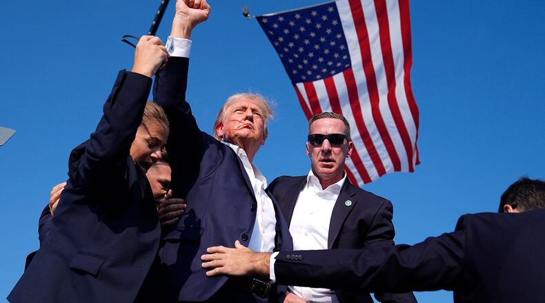 Donald Trump, surrounded by Secret Service, after a shooting happened at a campaign rally. AP Photo/Evan Vucci