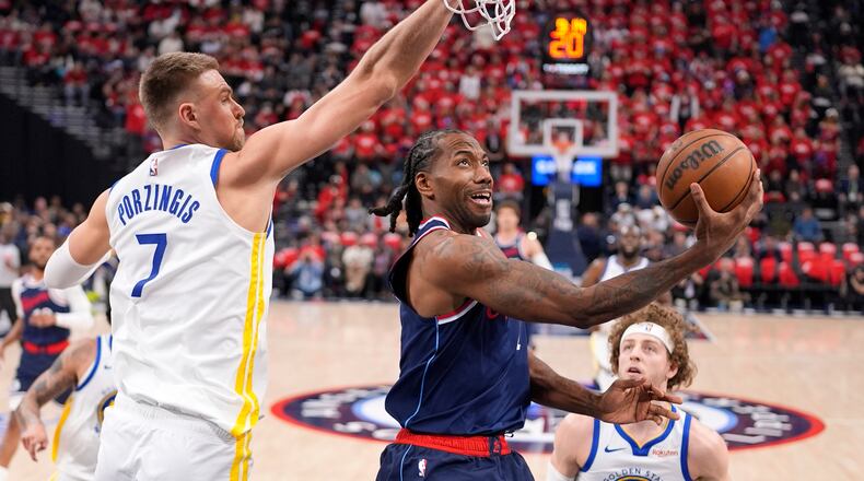 FILE - LA Clippers forward Kawhi Leonard, center, shoots as Golden State Warriors center Kristaps Porzingis defends during the first half of an NBA play-in tournament basketball game Wednesday, April 15, 2026, in Inglewood, Calif. (AP Photo/Mark J. Terrill,File)