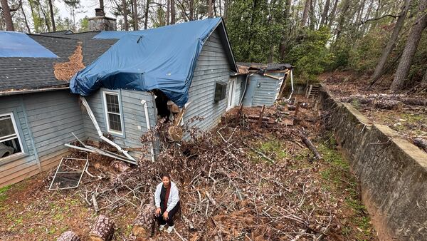 Chloe Trammell sits outside her family's house on White Owl Forest Drive in Augusta, six months after Hurricane Helene slammed the Georgia city. (Joe Kovac Jr. / AJC)