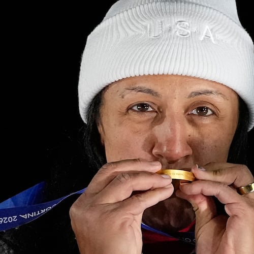 FILE - United States' gold medalist Elana Meyers Taylor kisses her medal on the podium of a women's monobob competition at the 2026 Winter Olympics in Cortina d'Ampezzo, Italy, Feb. 16, 2026. (AP Photo/Alessandra Tarantino, File)