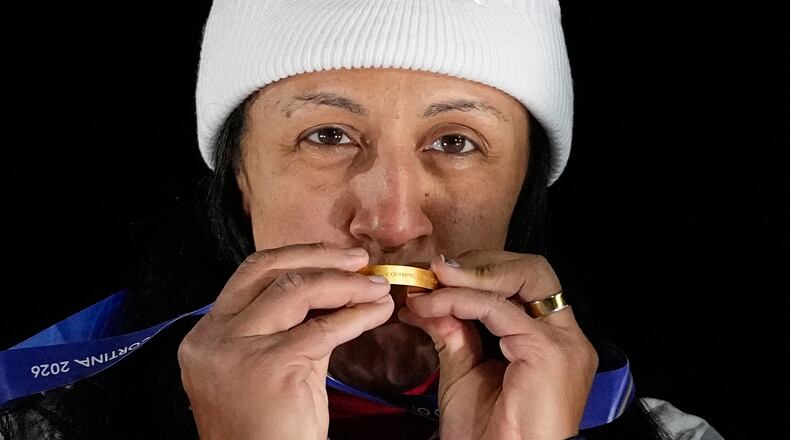 FILE - United States' gold medalist Elana Meyers Taylor kisses her medal on the podium of a women's monobob competition at the 2026 Winter Olympics in Cortina d'Ampezzo, Italy, Feb. 16, 2026. (AP Photo/Alessandra Tarantino, File)