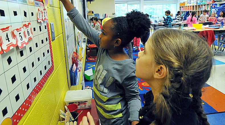 Second graders Dai Roberts (left) and Maya Tabachnikoff (right) work together as a team as they learn measurements in their classroom at Dunwoody Elementary school on Thursday, November 7, 2013. The controversy over whether to allow public schools in central DeKalb County operate independently under a "charter cluster" is happening miles away from Dunwoody Elementary, but this brightly-lit school outside the Perimeter will be affected by what happens miles away in Druid Hills.