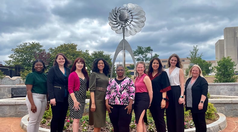 Lawrenceville Arts Commission and staff from left to right: Jasmine Billings, Amber Walden, Aura-Leigh Sanders, Katrina Fellows, Jennifer Hammond, Alice Stone- Collins, Nancy Alhabashi, Alicia Chitwood, Arlene Paris stand in front of the city's first kinetic art sculpture. (Courtesy City of Lawrenceville)