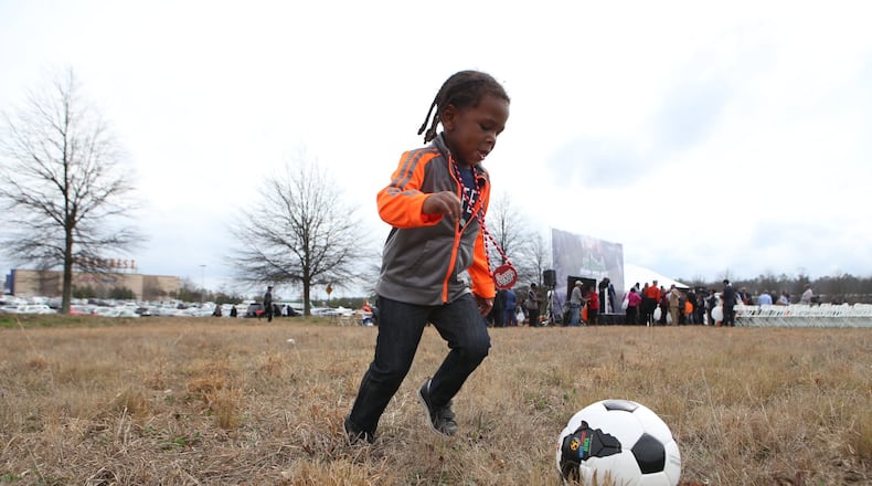 Harley Chapman plays with his newly acquired soccer ball at the end of the unveiling of the Atlanta Sports City sports complex site in Stonecrest on Wednesday. HENRY TAYLOR / HENRY.TAYLOR@AJC.COM