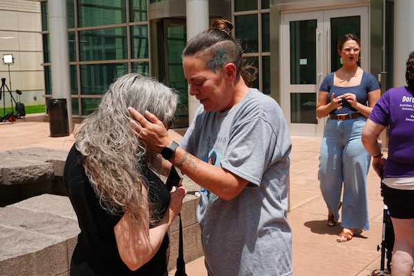 Crystina Page, right, hugs Beth Mosley after a Colorado funeral home owner who stashed nearly 190 decomposing bodies was sentenced to 20 years prison on federal fraud charges, Friday, June 27, 2025, in Denver. (AP Photo/David Zalubowski)