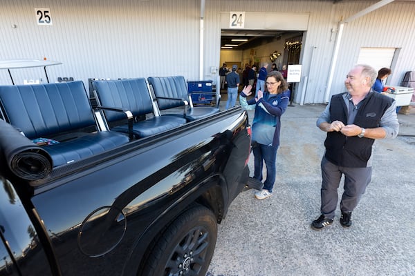 Michael and Carrie McCarthy of Lawrenceville check out the airport seats they purchased at the Delta Flight Museum Surplus Sale in Atlanta on Friday, Oct. 10, 2025. Every month, Delta fans wait in line for hours for the chance to buy vintage airline merch. (Arvin Temkar/AJC)