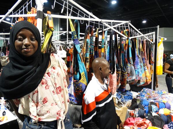 Hawa Drammeh (left) by bags she was selling. Her dad (who told me to shoo because he was working) is to her right. CREDIT: Rodney Ho/ rho@ajc.com