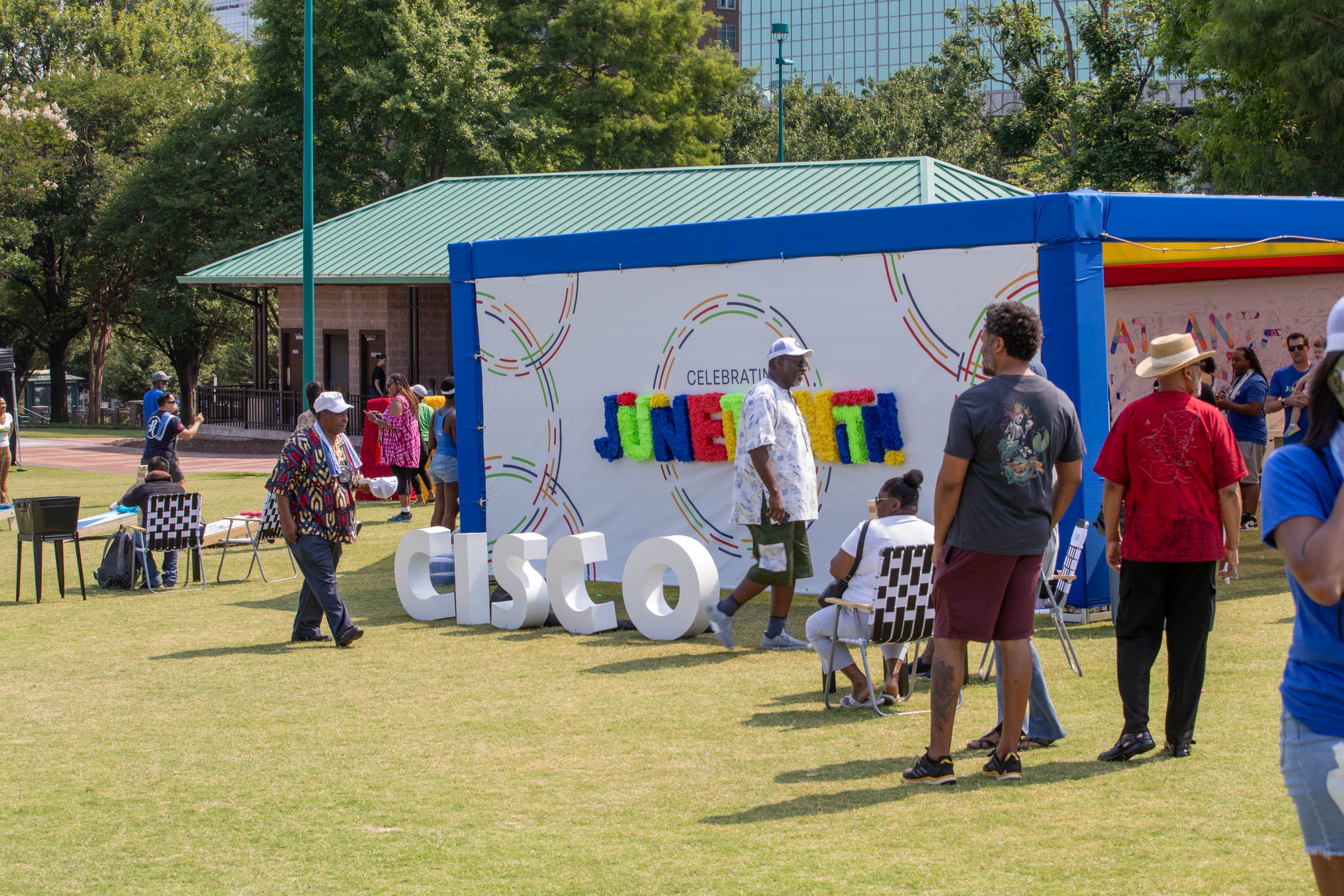 People observe and walk through Cisco’s stand at the Juneteenth Atlanta Parade and Music Festival in Atlanta on Saturday. (Katelyn Myrick/AJC)