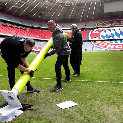 FILE - Workers prepare a goal post inside the FC Bayern Munich soccer stadium for an NFL football game at Allianz Arena in Munich, Germany, Wednesday, Nov. 9, 2022. (AP Photo/Matthias Schrader, File(