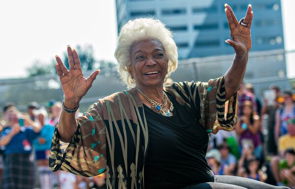 Nichelle Nichols, who played communications officer Lieutenant Uhura aboard the USS Enterprise in the popular Star Trek television series and succeeding motion pictures, gives the Vulcan symbol of live long and prosper as she rides down Peachtree St. during the annual DragonCon Parade in Atlanta on Saturday, September 5, 2015. JONATHAN PHILLIPS / SPECIAL