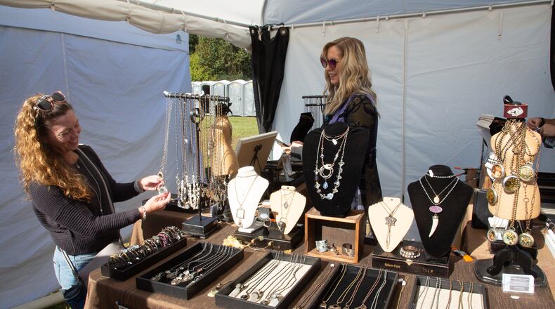 Rachel Nation helps a customer looking at jewelry during the Johns Creek Arts Festival on Sunday, October 17, 2021. (Photo: Steve Schaefer for The Atlanta Journal-Constitution)