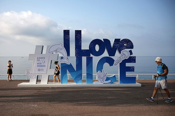 People walk on the sea promenade ahead of the UN Ocean Conference, Saturday, June 7, 2025 in Nice, French Riviera. (AP Photo/Laurent Cipriani)
