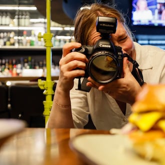 Atlanta-based lifestyle photographer Heidi Harris at work at the Painted Pickle, where she's using her own product: colorful light stands from her new company, Surrounded by Light. (Miguel Martinez/AJC)