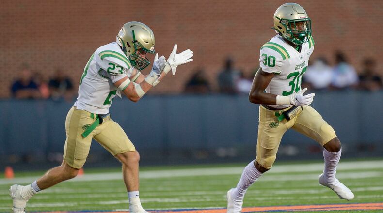Buford defensive players Jake Brittle (23) and Victor Payne (30) celebrate a North Cobb fumble in the first half of a regular-season game. (Daniel Varnado/Special to the AJC)