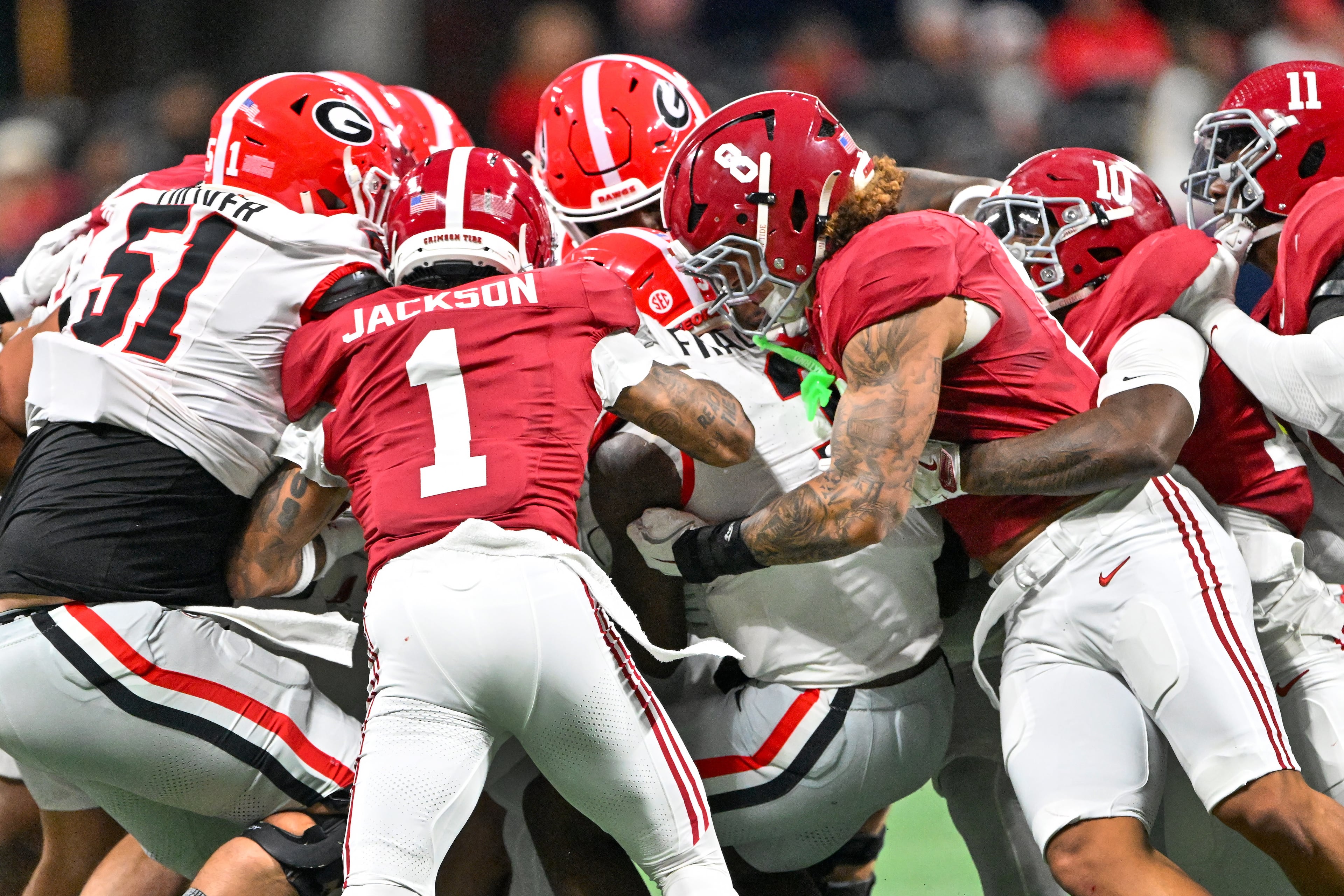 Georgia running back Nate Frazier (3) pushes for a first down against a wave of Alabama Crimson Tide defenders including Alabama defensive back Domani Jackson (1) during the first half of the SEC Championship game at Mercedes-Benz Stadium, Saturday, Dec. 6, 2025, in Atlanta. (Hyosub Shin / AJC)