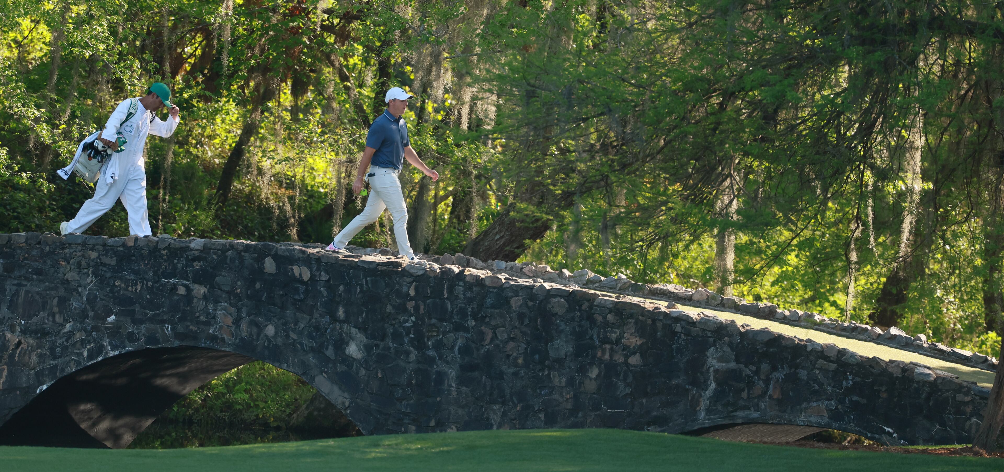Rory McIlroy and caddie Harry Diamond walk over bridge on 13th hole during final round of the Masters golf tournament, at Augusta National Golf Club, Saturday, April 13, 2025, in Augusta, Ga. (Jason Getz / AJC)