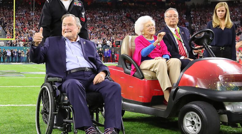 Former President George H.W. Bush gives the cheering crowd a thumbs up and former First Lady Barbara Bush waves as they take the field for the coin toss while the Atlanta Falcons meet the New England Patriots in Super Bowl LI at NRG Stadium in Houston, TX, Sunday, February 5, 2017. Curtis Compton/AJC