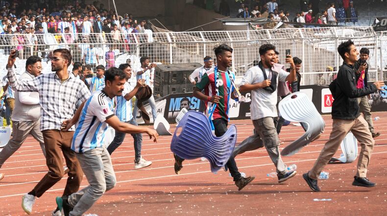 Indian fans vandalize stadium chairs as they run on to the field after failing to get a glimpse of Argentine soccer star Lionel Messi at the Salt Lake Stadium, in Kolkata, India, Saturday, Dec. 13, 2025. (AP Photo/Bikas Das)