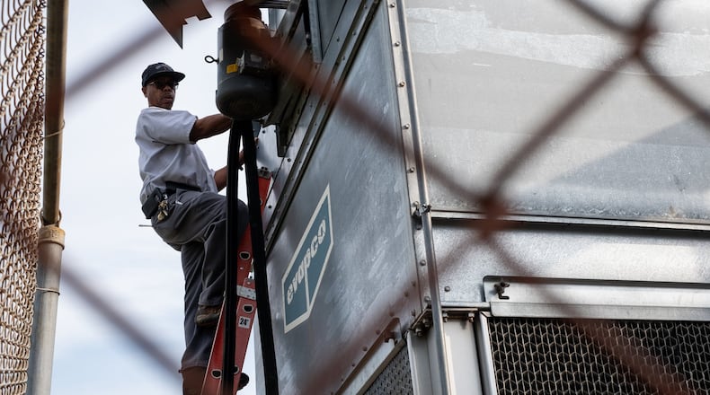Reggie Turner, an HVAC master craftsman with Gwinnett County schools, works on a chiller in 2020 at Shiloh Middle School in Snellville. (Ben Gray for the Atlanta Journal-Constitution)