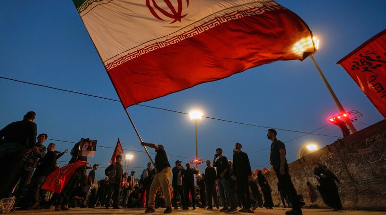 A man waves an Iranian flag during funeral ceremonies for slain Iranian Supreme Leader Ayatollah Ali Khamenei and members of his family at Imam Khomeini Mosalla Grand Mosque in Tehran, Iran, Sunday, July 5, 2026. (AP Photo/Altaf Qadri)