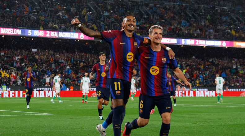 Barcelona's Raphinha celebrates with Gavi, right, after scoring his side's fifth goal from the penalty spot during a Spanish La Liga soccer match between Barcelona and Racing de Santander in Barcelona, Spain, Wednesday, Sept. 16, 2026. (AP Photo/Joan Monfort)