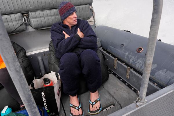 Endurance swimmer Louis Pugh warms up on the ride back to shore after completing the first leg of his swim around Martha's Vineyard, Thursday, May 15, 2025, off Edgartown, Mass. (AP Photo/Robert F. Bukaty)
