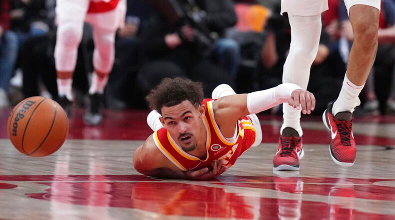 Atlanta Hawks guard Trae Young (11) looks toward the loose ball as he falls to the floor after being fouled during the second half of an NBA basketball game in Toronto on Tuesday, April 5, 2022. (Nathan Denette/The Canadian Press via AP)