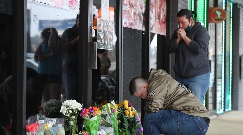 031721 Acworth: U.S. Army veteran Latrelle Rolling (left) and Jessica Lang (right) both pause to pray after dropping off flowers at Young’s Asian Massage where four people were killed on Wednesday, March 17, 2021, in Acworth. At least eight people were found dead at three different spas in the Atlanta area Tuesday by suspected killer Robert Aaron Long.  “Curtis Compton / Curtis.Compton@ajc.com”