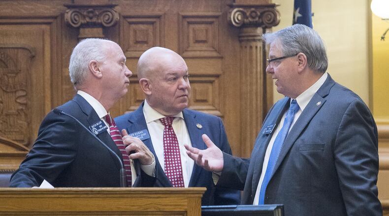 State Senate President Pro Tem Butch Miller, from left, Senate Majority Leader Mike Dugan and Senate Minority Leader Steve Henson discuss chamber rules during the first day of the Georgia legislative session. (ALYSSA POINTER/ALYSSA.POINTER@AJC.COM)