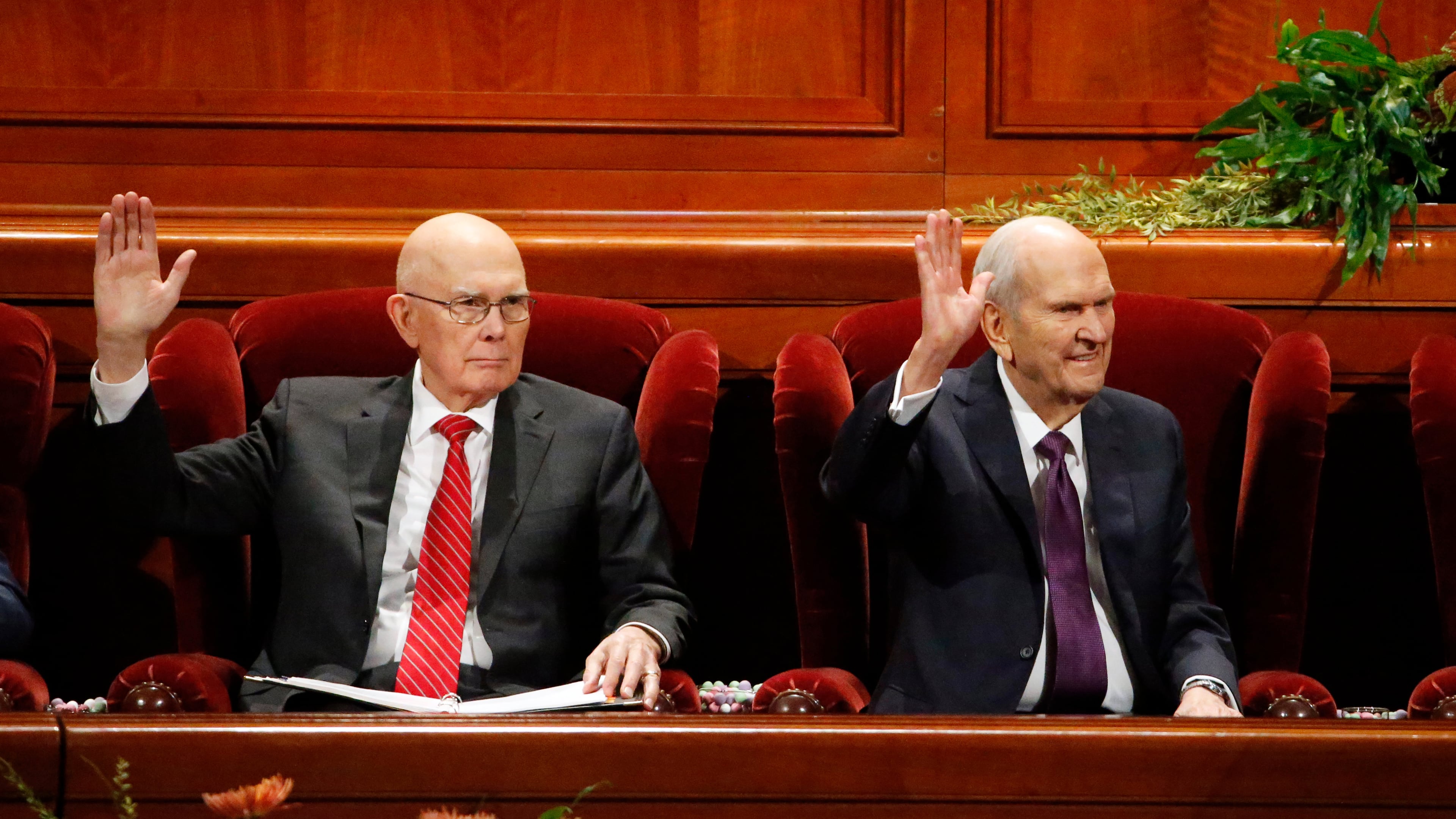 FILE - President Russell M. Nelson, right, raises his hand during a sustaining vote with his counselor, Dallin H. Oaks, left, during The Church of Jesus Christ of Latter-day Saints' twice-annual church conference Oct. 5, 2019, in Salt Lake City. (AP Photo/Rick Bowmer, File)
