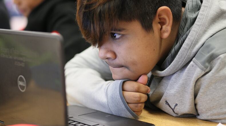 Seventh grader Melvin Evaristo, 12, uses a school laptop during a reading class at Crabapple Middle School on Friday, Feb. 21, 2020, in Roswell. At Crabapple Middle School, the adults are specific about their tech use. When it’s for an assignment, the devices come out. MIGUEL MARTINEZ FOR THE ATLANTA JOURNAL-CONSTITUTION