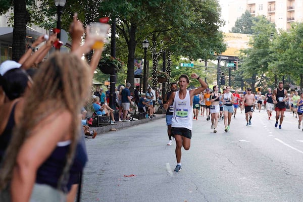 Spectators cheer on racers during last summer's Peachtree. (Natrice Miller/AJC)